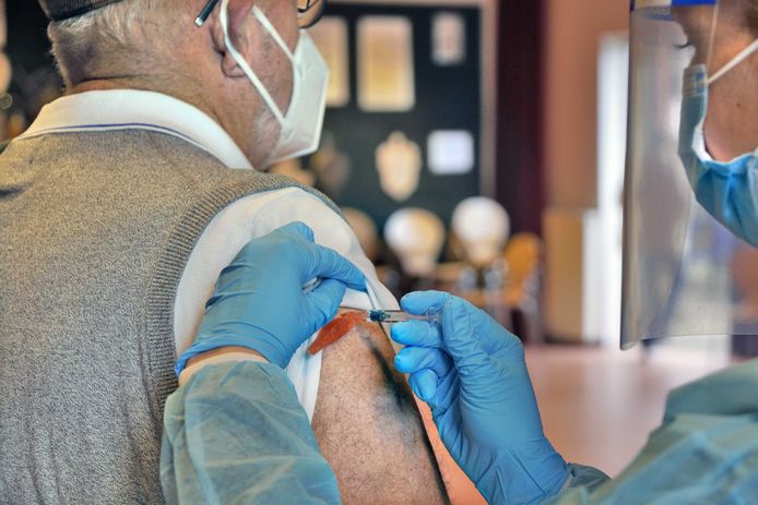 Een man wordt ingeent tegen het griepvirus.