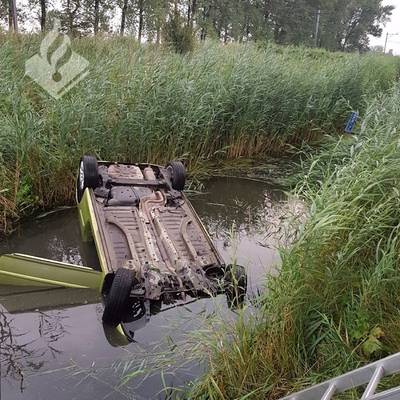 Drie mensen roepen om hulp vanuit auto die ondersteboven in de sloot ligt