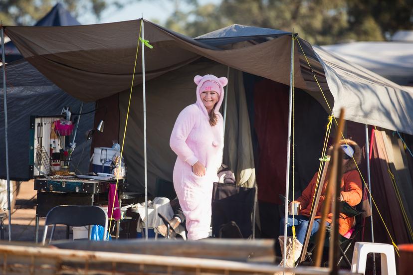 Vrouw verkleed in onesie op festival camping