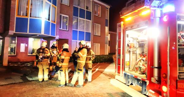 Brand in Berghem, vrouw hoestend en proestend de ambulance in.