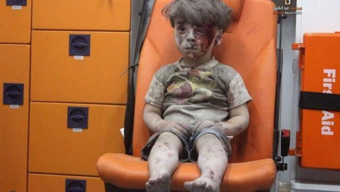 De 5-jarige Omran vlak na de luchtaanval op zijn appartementencomplex