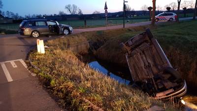 Auto op de kop in de sloot door botsing in Achterberg