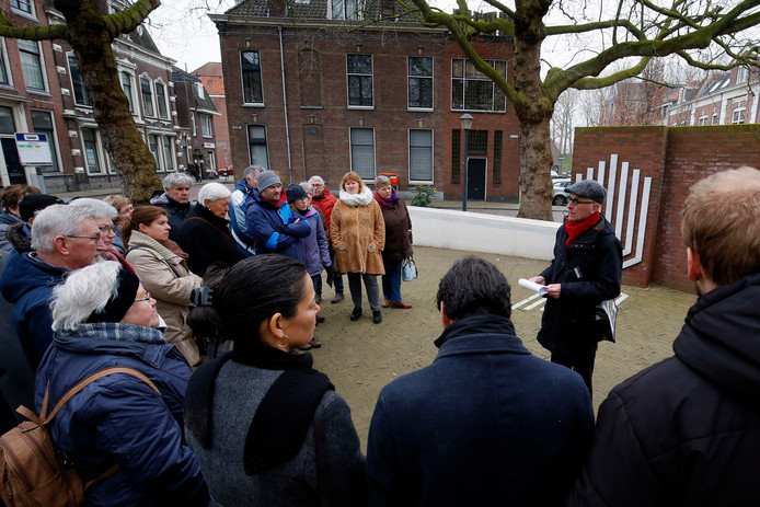 Stadsgids Dick Bosch neemt een groep mensen mee voor een wandeling langs historische locaties met een link naar de Tweede Wereldoorlog.