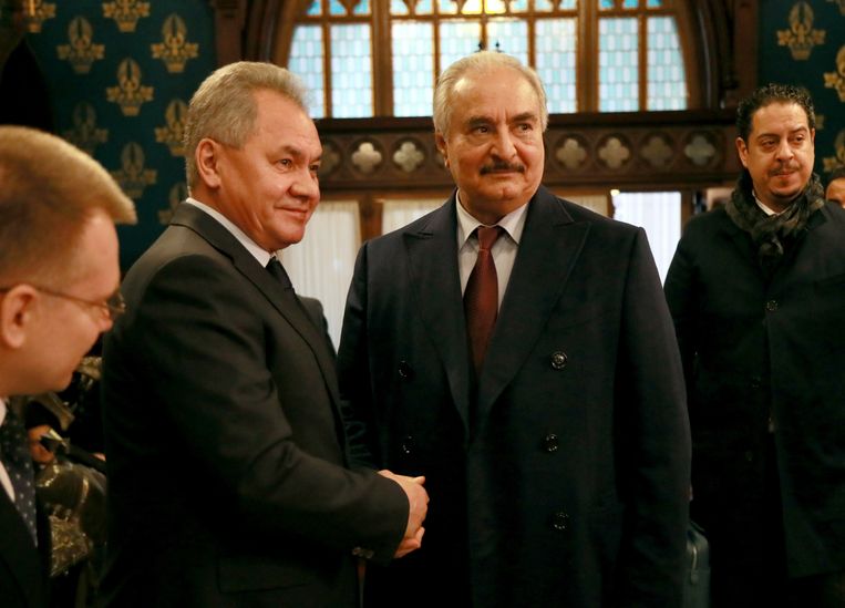 De Libische krijgsheer Khalifa Haftar (midden) schudt de Russische minister van Defensie Sergej Sjojgoe (links) de hand bij de besprekingen in Moskou over een wapenstilstand tussen de troepen van Haftar en het leger van de internationaal erkende regering van premier Fayez al-Serraj in Tripoli. Haftar vertrok zonder zijn handtekening te zetten onder het akkoord. Beeld EPA