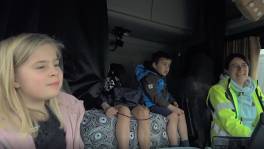 Brenda voert haar kinderen met de truck naar school