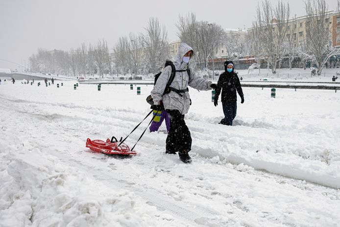 epa08928119 A couple walks along the M30 ring road covered in a thick layer of snow in Madrid, Spain, 09 January 2021. Storm Filomena brought the heaviest snowfall in decades. EPA/Rodrigo Jimenez