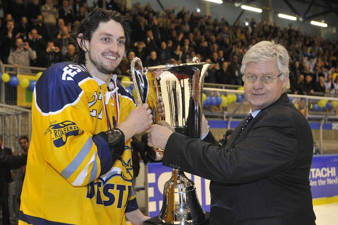 Ruud Vreeman, voorzitter van de Nederlandse IJshockey Bond, reikt de beker uit aan Hagemeijer.