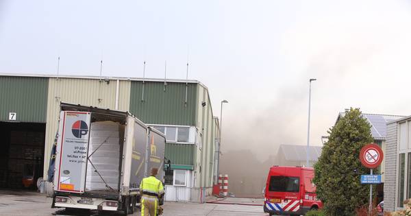 Brand bij houtverwerkingsbedrijf Plomp & Zn BV in Waardenburg, brandweer blust na