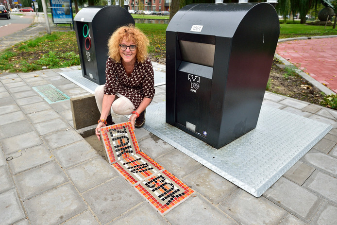 Jeanette Nieuwesteeg legt mozaiektegels bij vuilcontainers met teksten als 'zak in bak' en 'geen los vuil'.