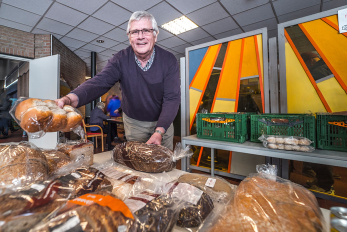 Voedselbank Delft-voorzitter Hans Mostert toont enkele producten die in de pakketten zitten.