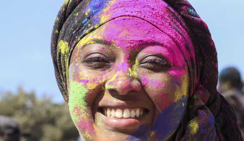 Vrouw met gekleurd poeder op gezicht op Holi Festival