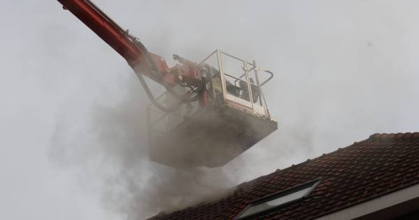 Woningbrand in Eindhoven, brandweer aanwezig met reddingsvoertuig.