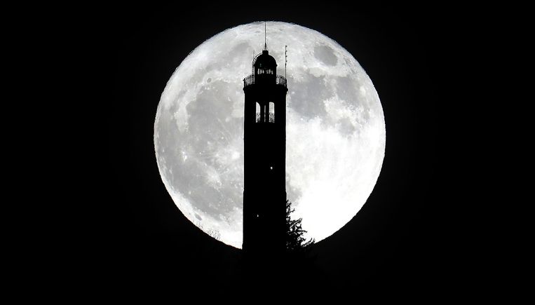 De supermaan boven de toren San Maurizio in Brunate, dicht bij Como, Italië.