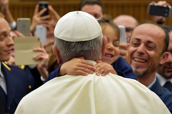 Een klein meisje knuffelt paus Franciscus in Vaticaanstad, op 21 mei 2015.