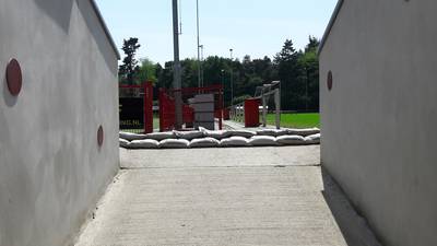 Zandzakken voor de deur na overstroomde kleedkamers in Alverna