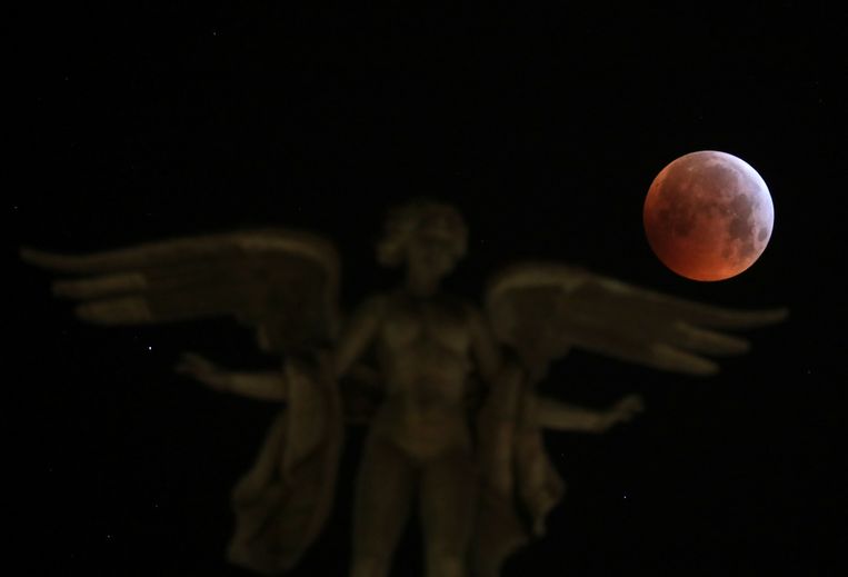 De maan boven het Victoria Alada-standbeeld in Madrid.